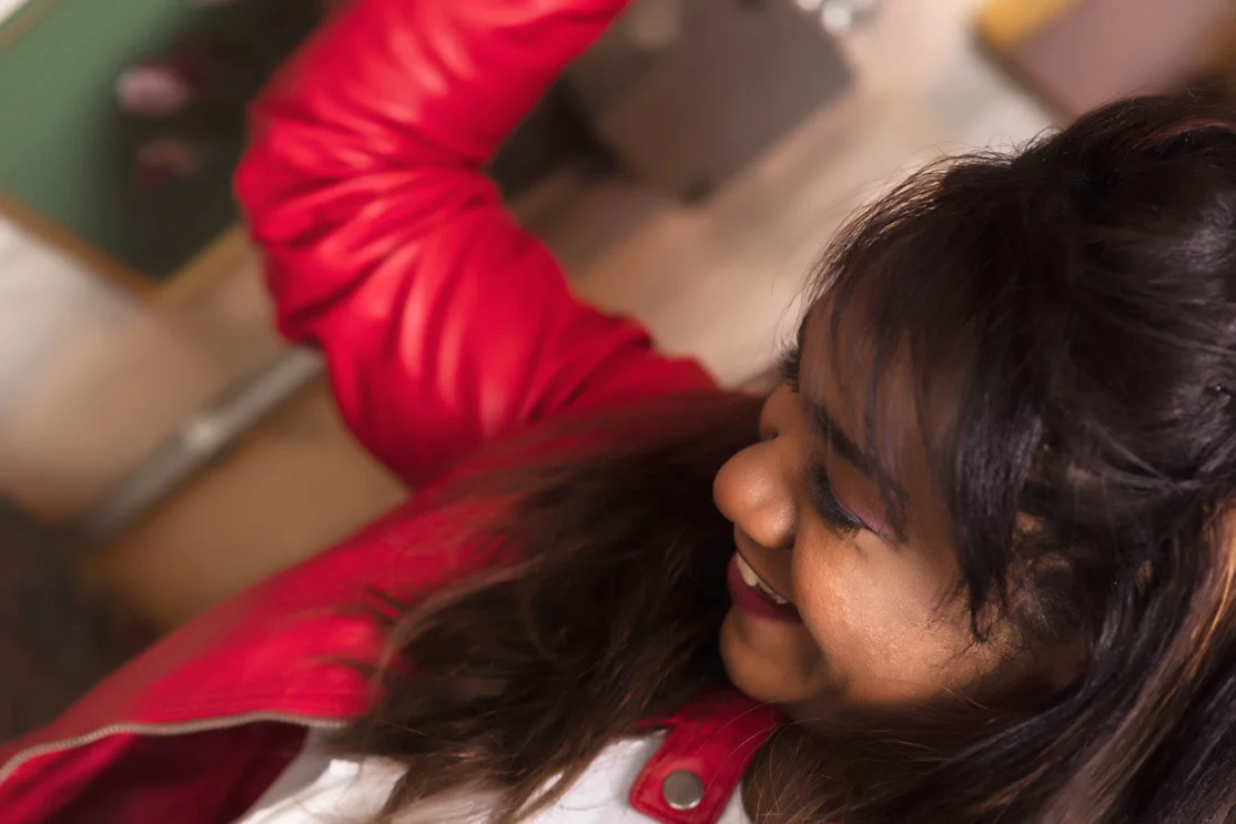 Close-up of Magela Herrera smiling, wearing a red leather jacket
