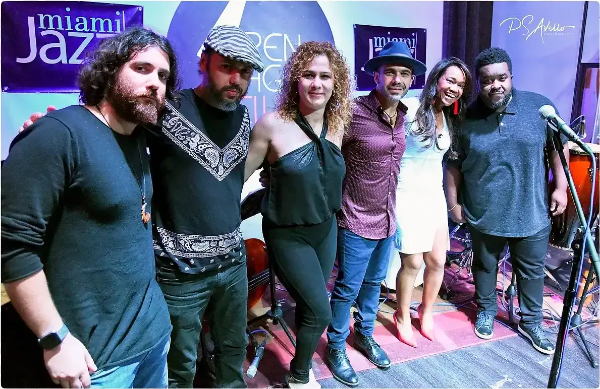 Magela Herrera smiling with her band on stage